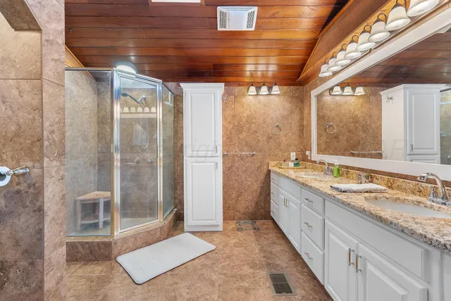 a spacious bathroom with a granite countertop sink and mirror