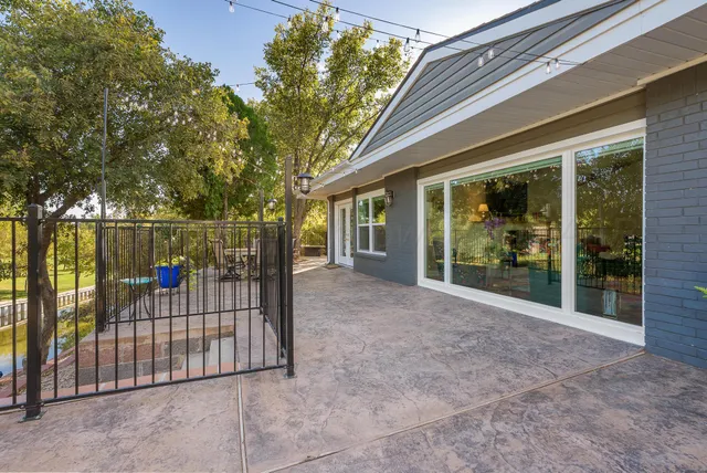 a view of a backyard with large trees and wooden fence