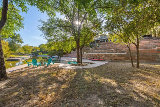 a view of a yard with plants and a brick wall