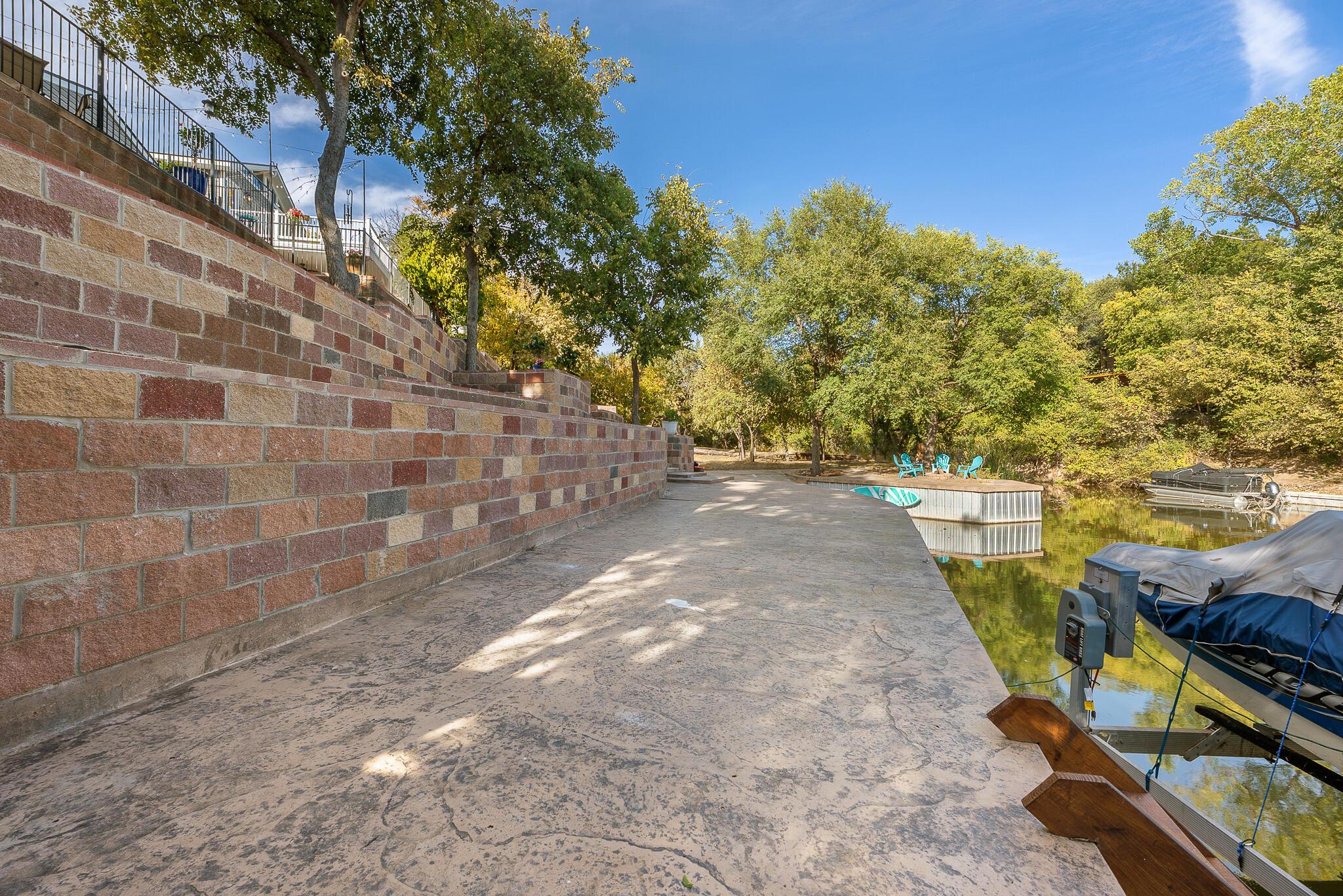 110 Caprock Lane Amarillo, TX 79118 - Photo 34 of 46 a view of a yard with plants and a brick wall