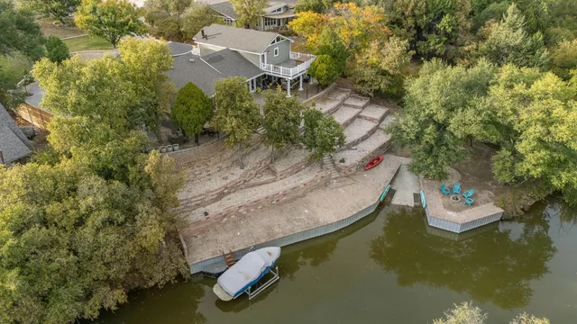 an aerial view of residential houses with outdoor space and trees