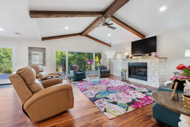 a living room with furniture a flat screen tv and a fireplace