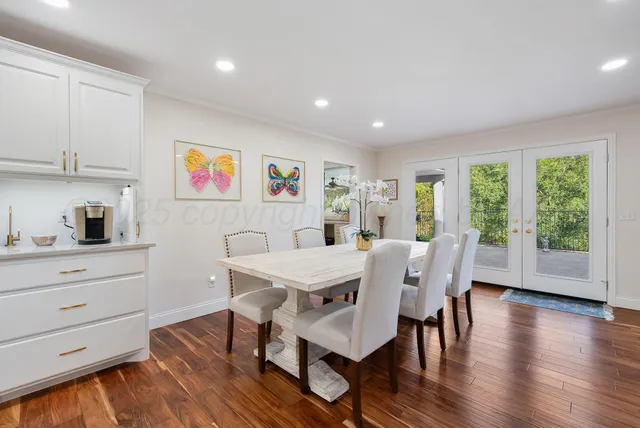 a view of a dining room with furniture a rug and wooden floor