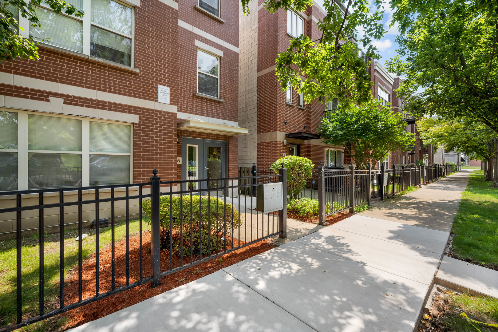 907 South Lytle Street, Unit 201 Chicago, IL 60607 - Photo 2 of 28 a view of a brick house with large windows and a small yard