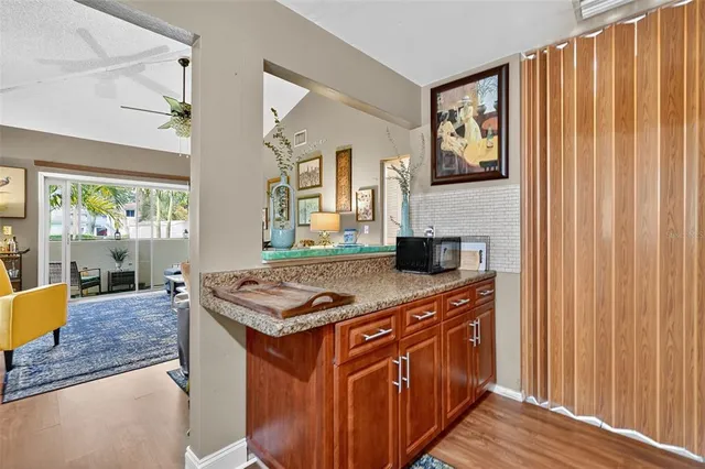 a kitchen with stainless steel appliances granite countertop a stove a sink dishwasher and a dining table with wooden floor