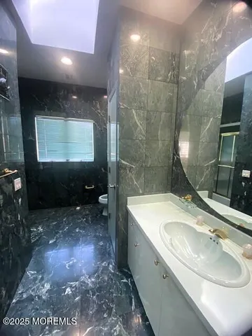 a bathroom with a sink a toilet and shower