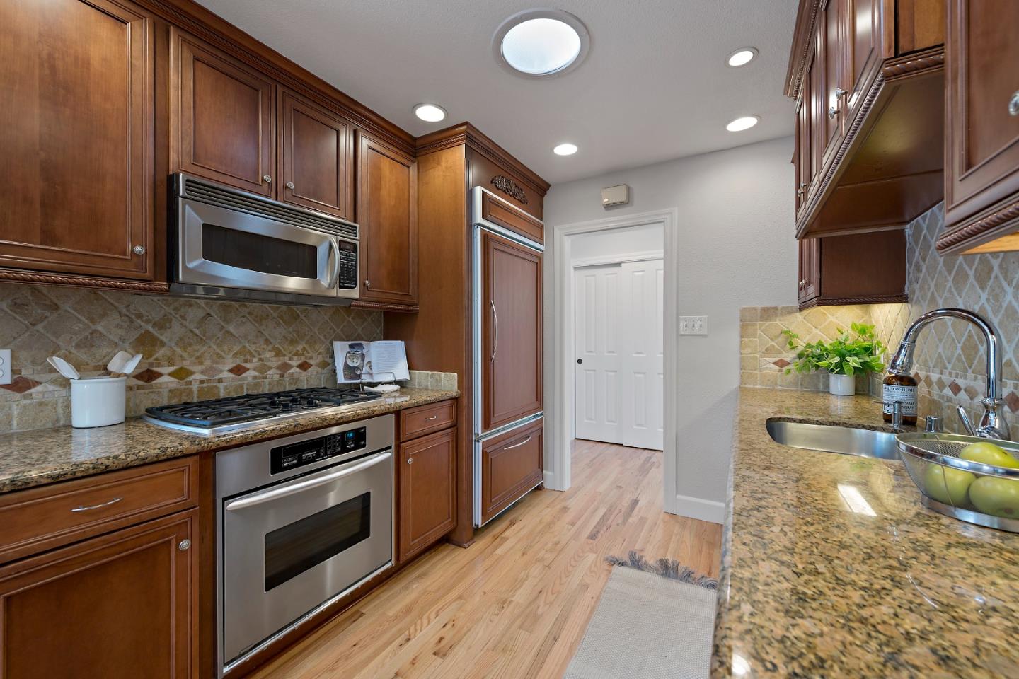 16131 Jacaranda Way Los Gatos, CA 95032 - Photo 11 of 30 a kitchen with granite countertop wooden cabinets stainless steel appliances and a counter space