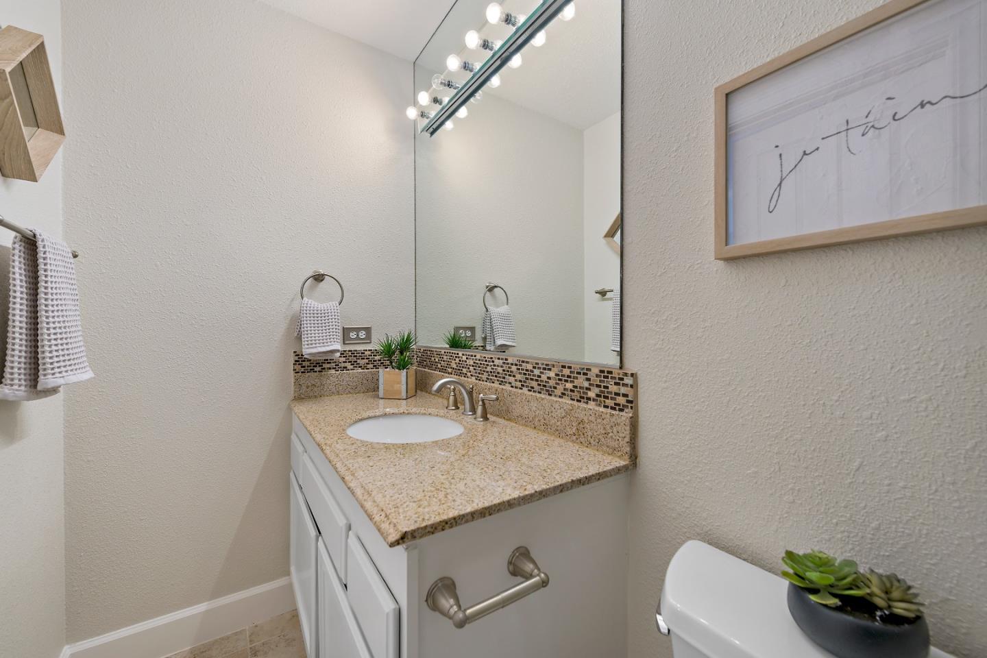 16131 Jacaranda Way Los Gatos, CA 95032 - Photo 19 of 30 a bathroom with a granite countertop sink a toilet and a mirror