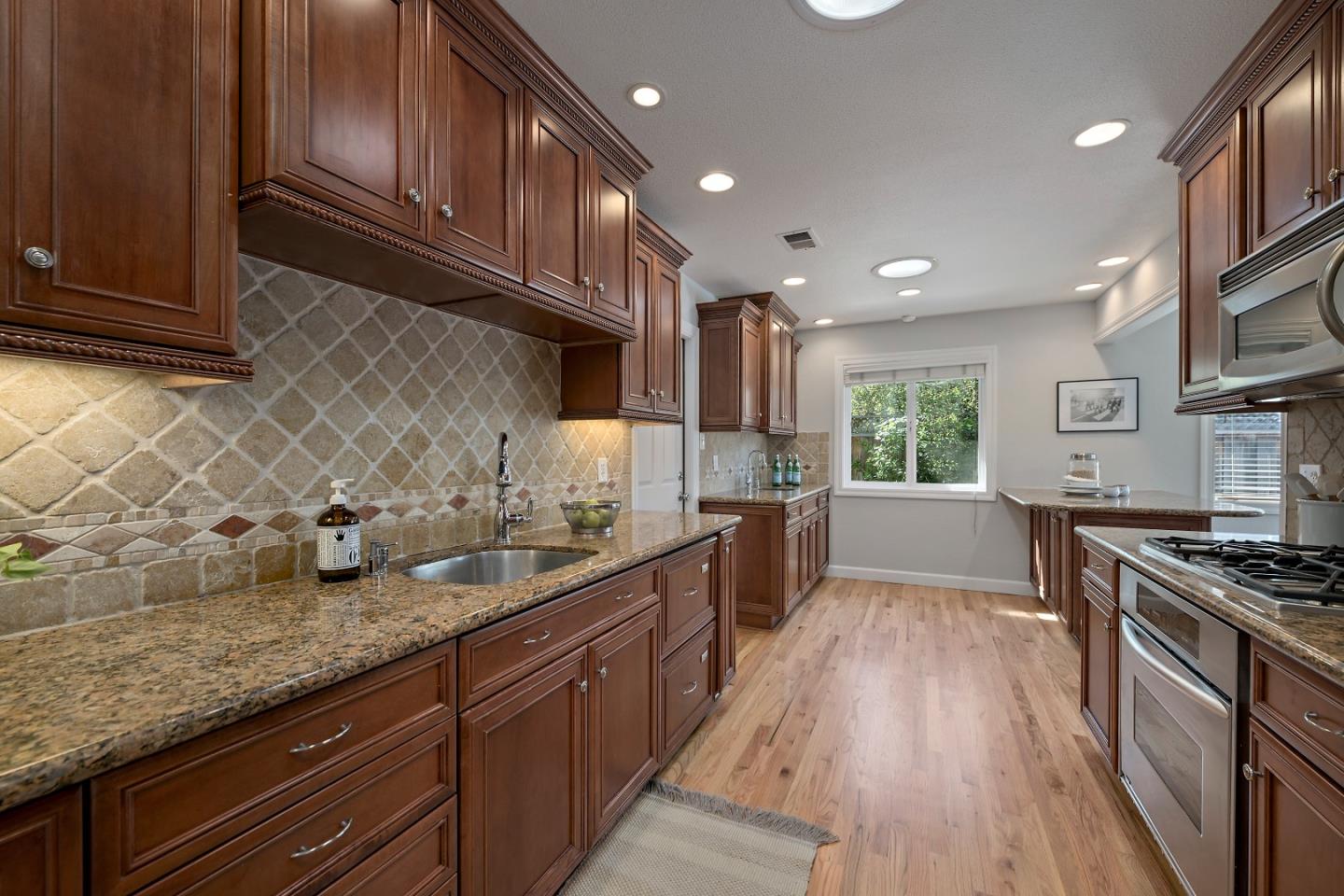 16131 Jacaranda Way Los Gatos, CA 95032 - Photo 10 of 30 a kitchen with granite countertop stainless steel appliances a sink a stove top oven a counter space and cabinets