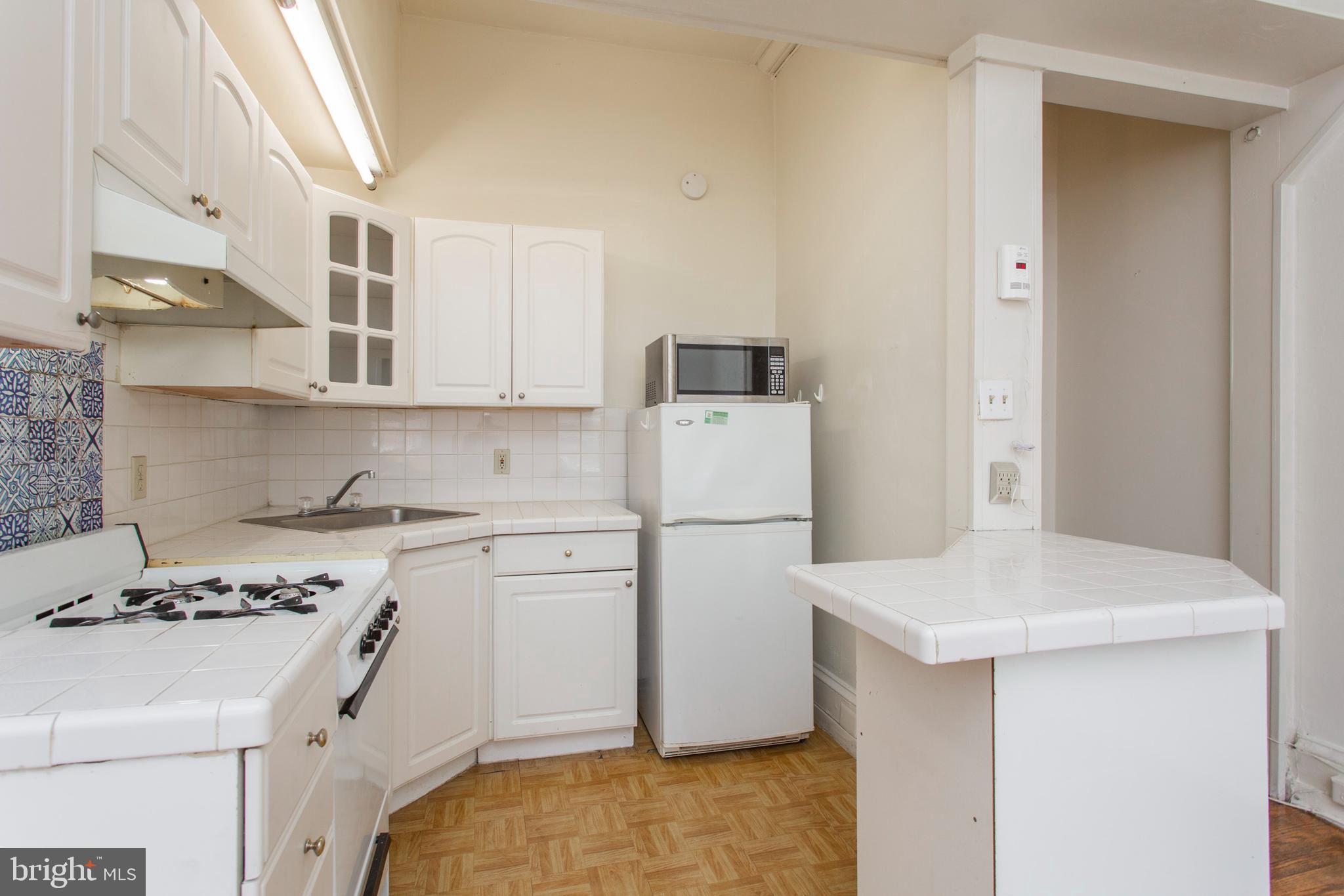1807 Spruce Street, Unit 2F Philadelphia, PA 19103 - Photo 6 of 17 a kitchen with a stove a sink and a refrigerator