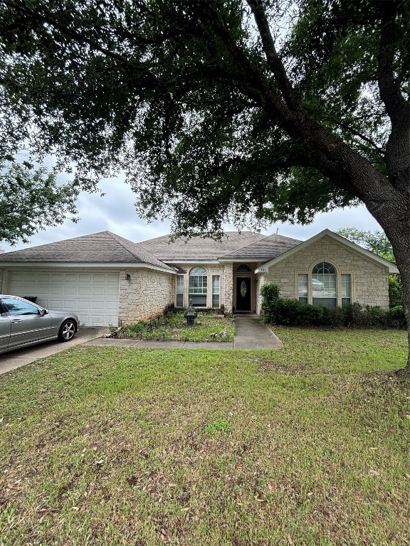 a front view of a house with a garden and trees