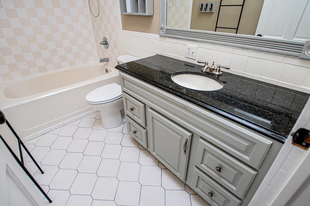75 Cash Lane Bremen, GA 30110 - Photo 51 of 92 a bathroom with a granite countertop sink toilet a mirror and bathtub