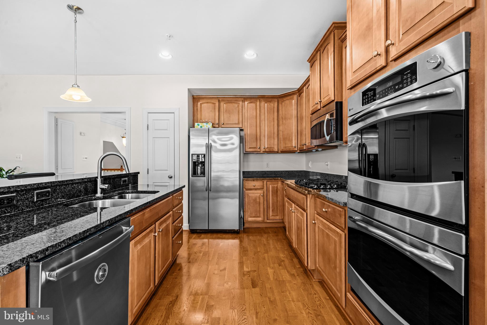 5725 Callcott Way, Unit P Alexandria, VA 22312 - Photo 11 of 40 a kitchen with stainless steel appliances granite countertop a stove a sink and a refrigerator