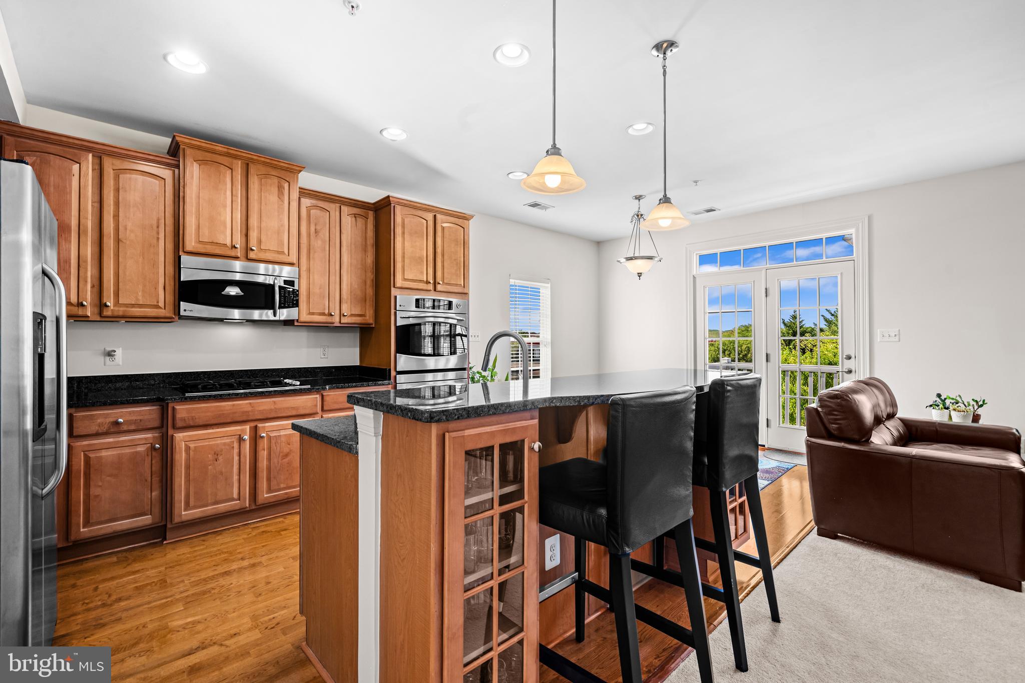 5725 Callcott Way, Unit P Alexandria, VA 22312 - Photo 14 of 40 a kitchen with stainless steel appliances granite countertop a stove a sink a microwave a dining table and chairs with wooden floor