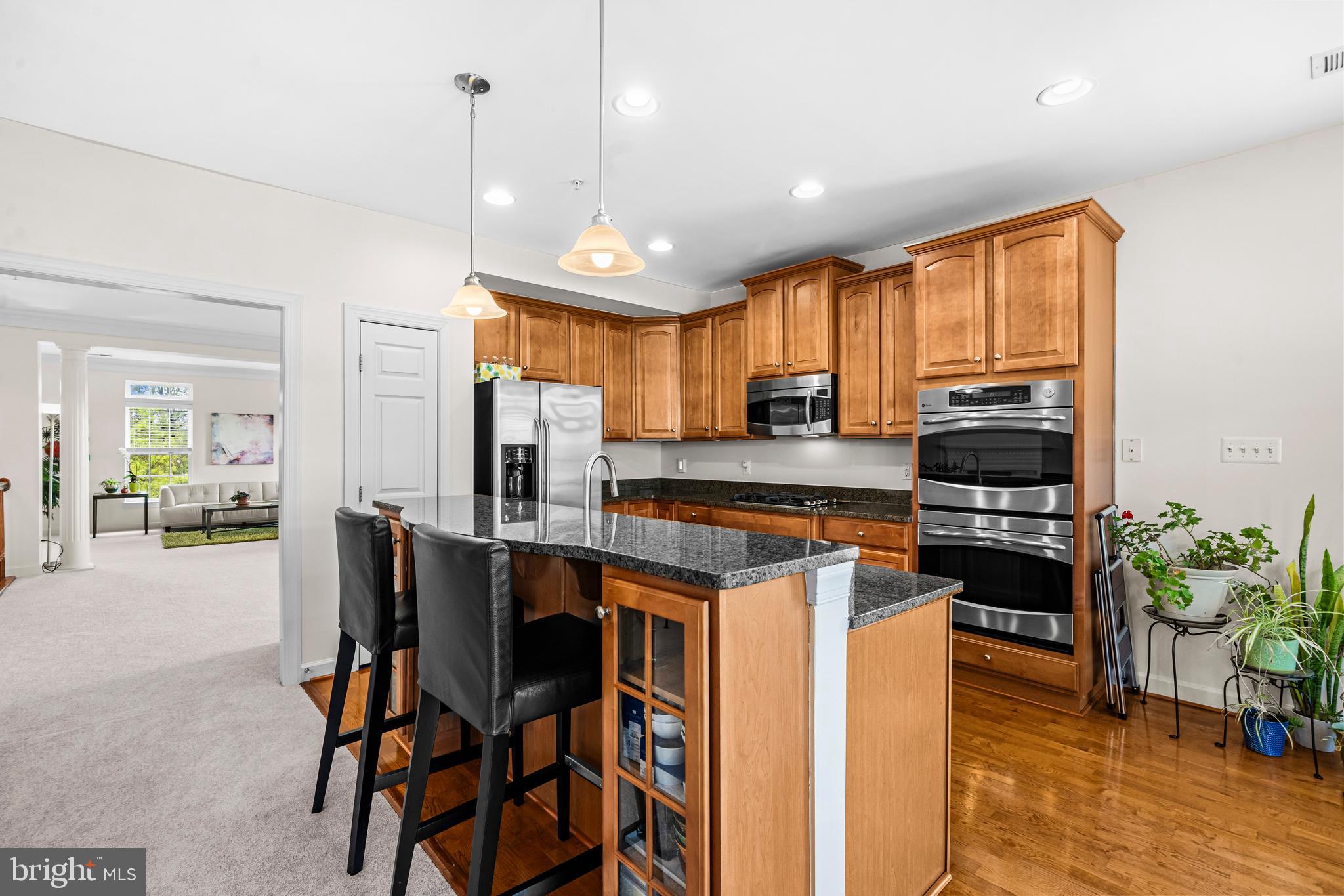 5725 Callcott Way, Unit P Alexandria, VA 22312 - Photo 8 of 40 a kitchen with stainless steel appliances granite countertop a stove a refrigerator a oven a sink a dining table and chairs with wooden floor