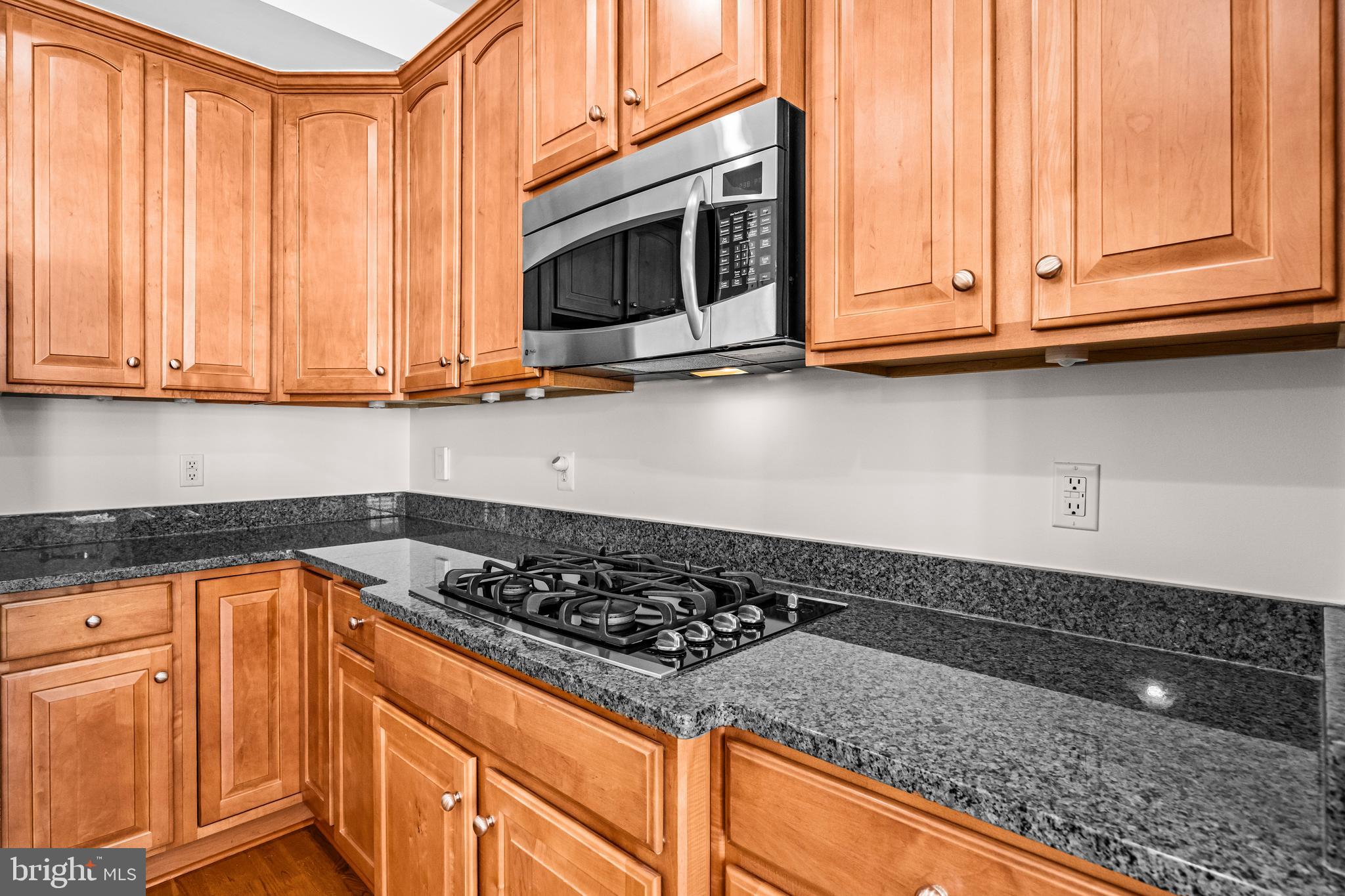 5725 Callcott Way, Unit P Alexandria, VA 22312 - Photo 10 of 40 a kitchen with granite countertop stainless steel appliances a stove a microwave and cabinets