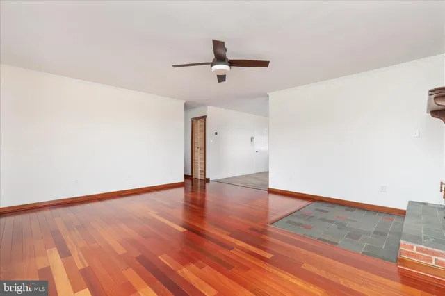 a view of an empty room with wooden floor