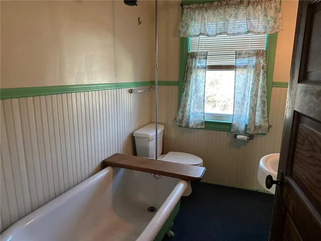 a bathroom with a toilet a sink and mirror