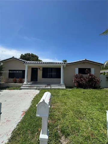 a front view of a house with a garden and yard