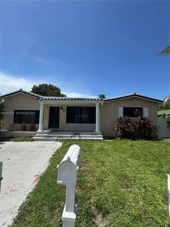 a front view of a house with a garden and yard