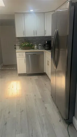 a kitchen with stainless steel appliances granite countertop a refrigerator a sink and a stove