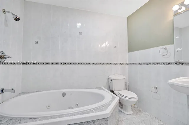 a white bath tub sitting next to a white toilet