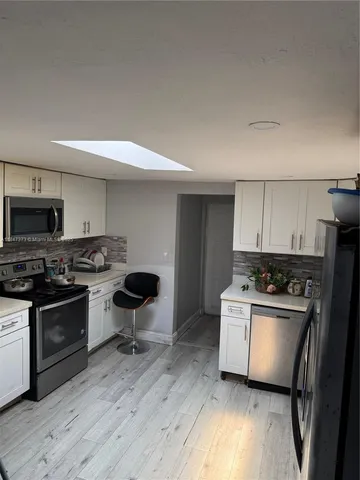 a kitchen with stainless steel appliances a stove a sink and a refrigerator