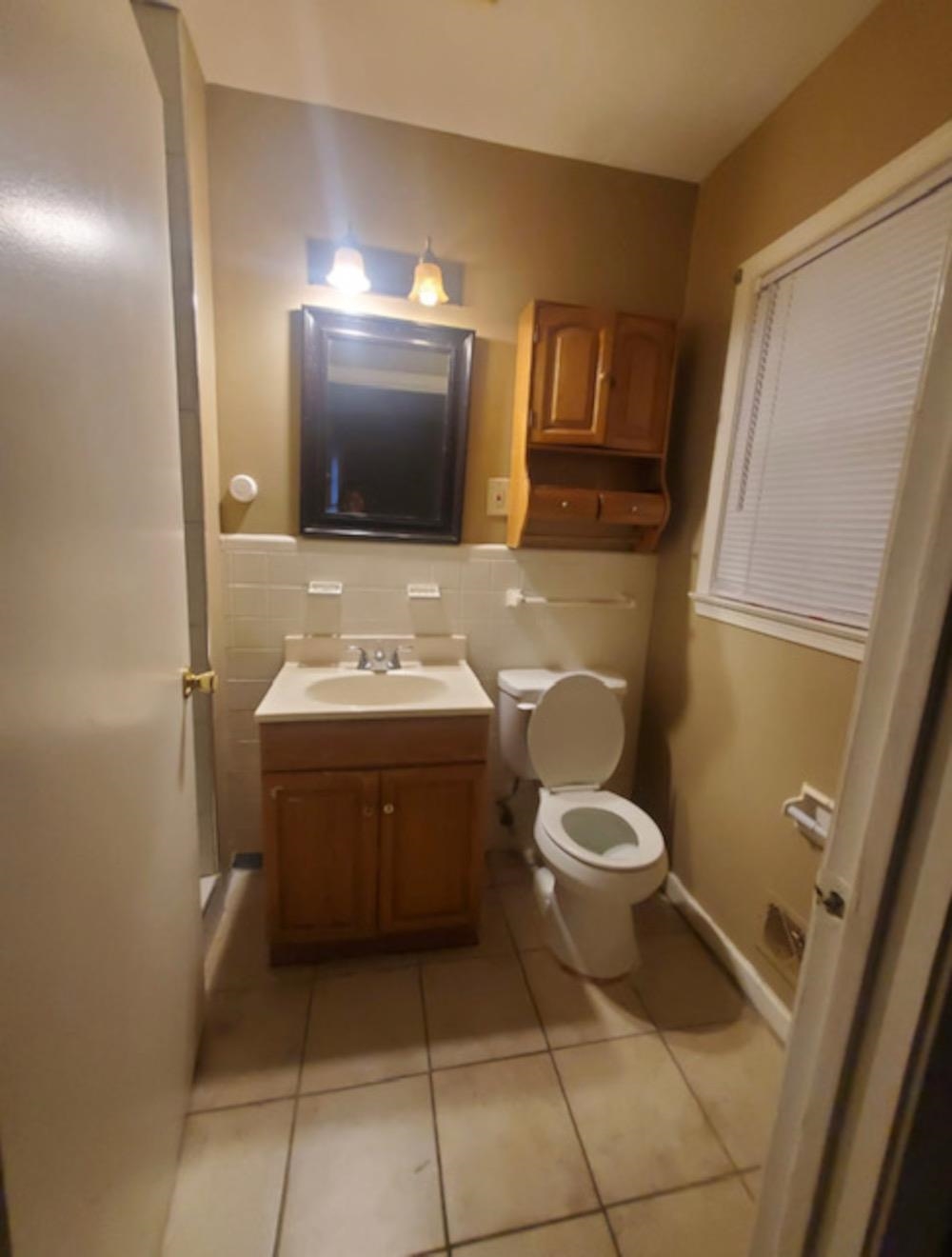 1624 Whitney Avenue Memphis, TN 38127 - Photo 6 of 9 a bathroom with a toilet sink and mirror