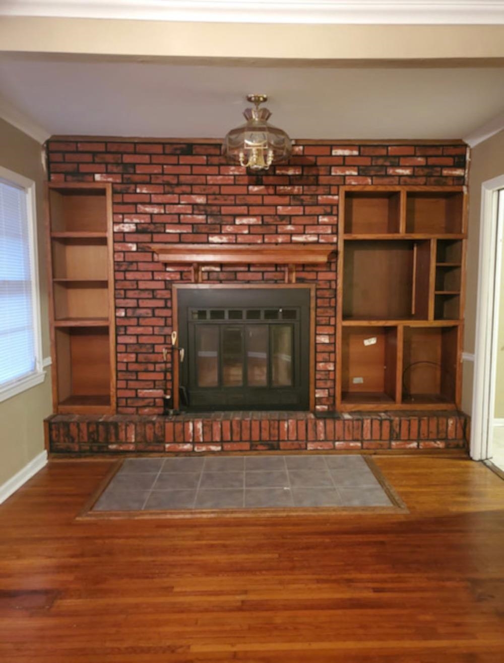 1624 Whitney Avenue Memphis, TN 38127 - Photo 8 of 9 a view of an empty room with wooden floor and a fireplace