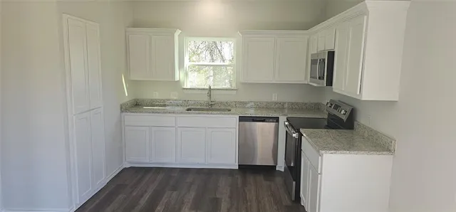 a kitchen with a sink cabinets and window