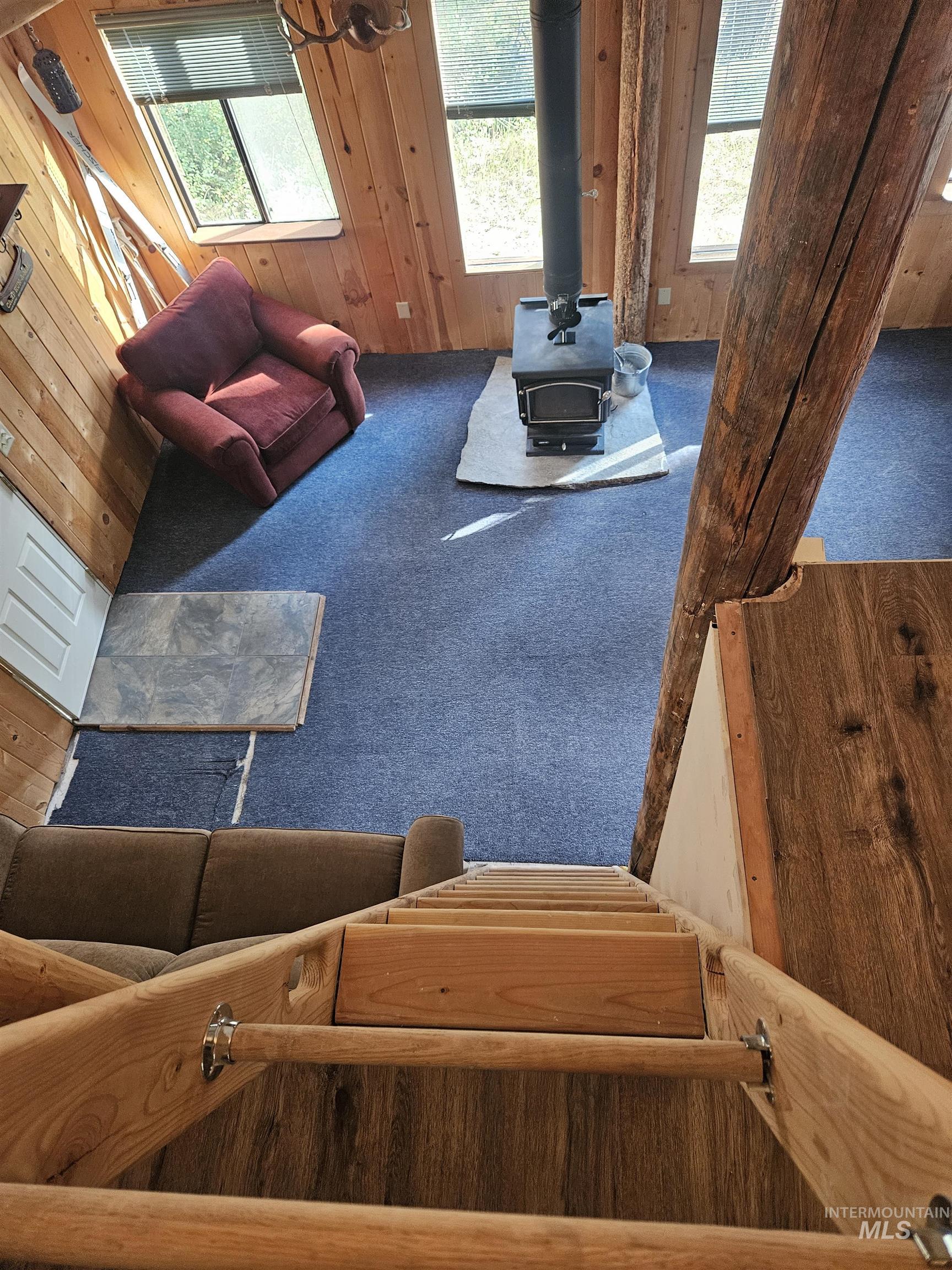 1510 Crown Point Parkway Cascade, ID 83611 - Photo 13 of 19 Living area with carpet, a wood stove, and wood walls