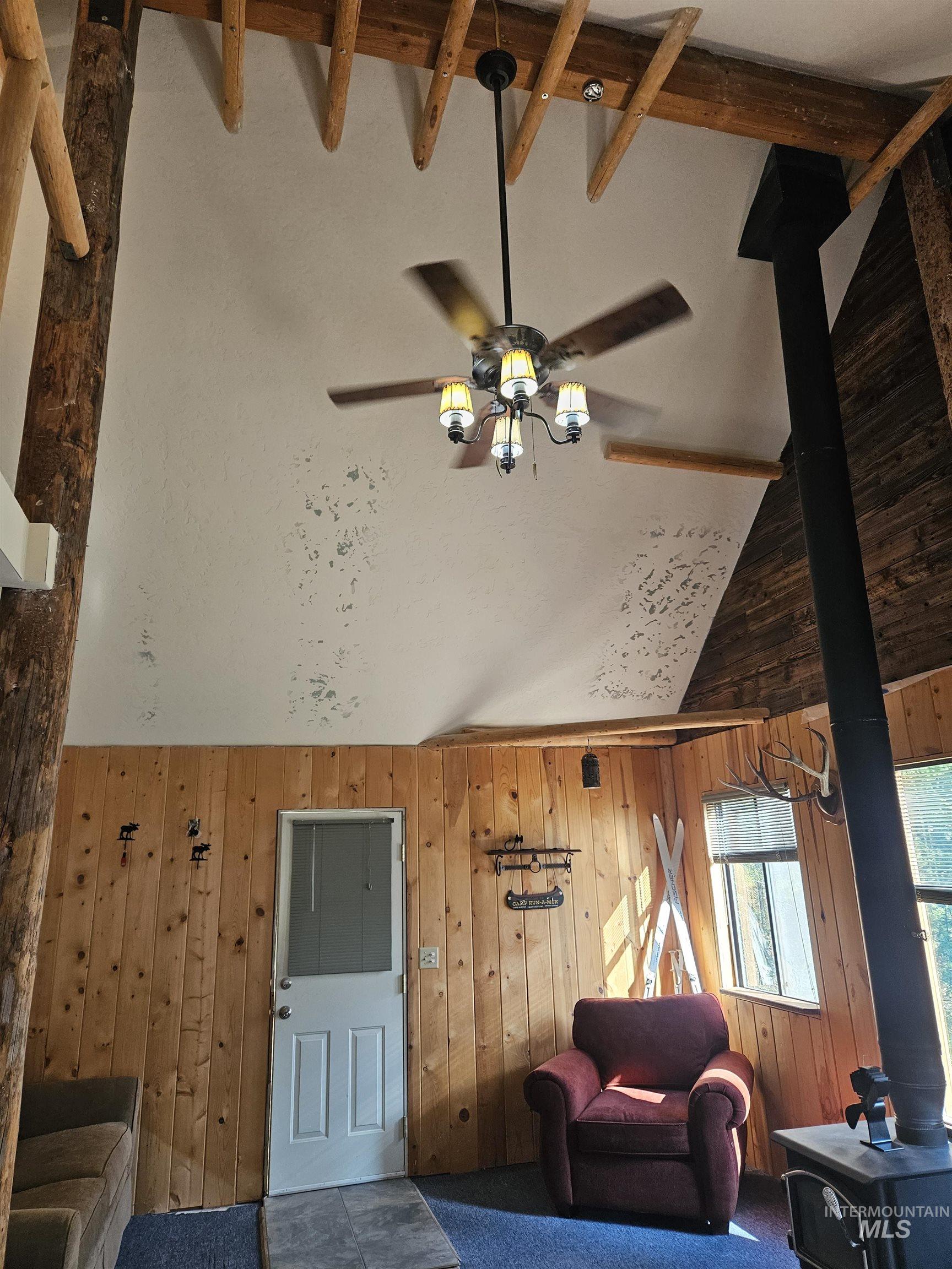 1510 Crown Point Parkway Cascade, ID 83611 - Photo 18 of 19 Living room with high vaulted ceiling, a wood stove, and wooden walls