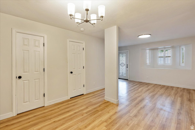 38 South 1000th Street East Payson, UT 84651 - Photo 7 of 19 Open-concept living space with light wood-finish flooring, white walls, and a contemporary chandelier