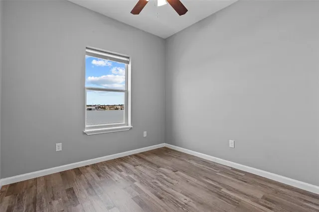 an empty room with a window and a chandelier fan