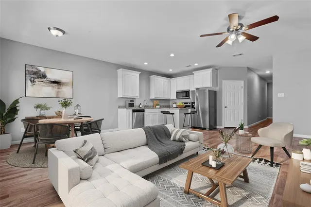 a living room with furniture kitchen view and a dining table