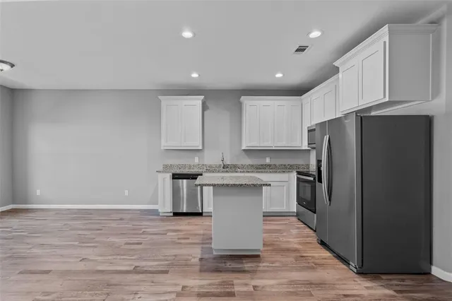 a kitchen with stainless steel appliances granite countertop a refrigerator sink and cabinets