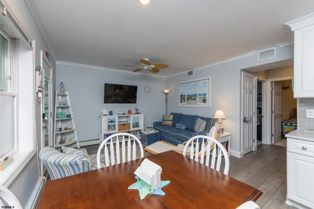 a living room with furniture a flat screen tv and a dining table