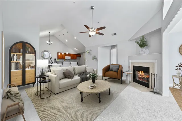 a living room with furniture a fireplace and a chandelier