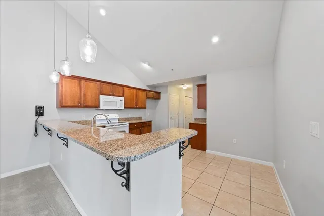 a kitchen with stainless steel appliances granite countertop a sink a stove and a refrigerator