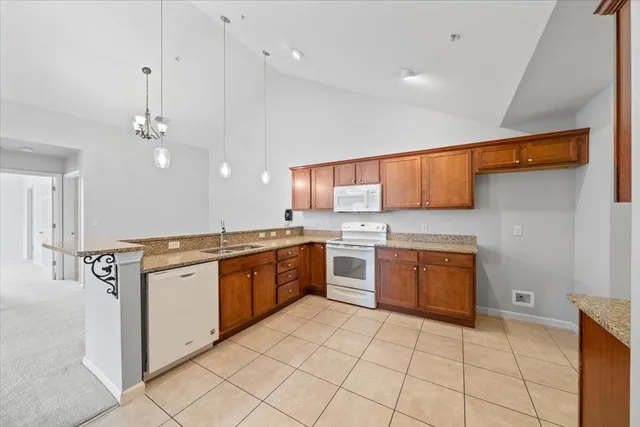 a large kitchen with granite countertop a sink a stove top oven and cabinets
