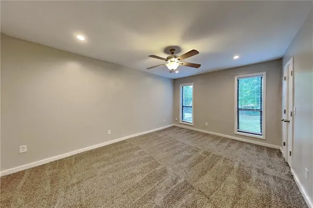 a view of an empty room with a chandelier fan