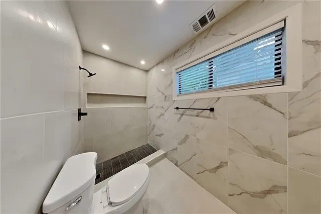 a bathroom with a toilet and a shower