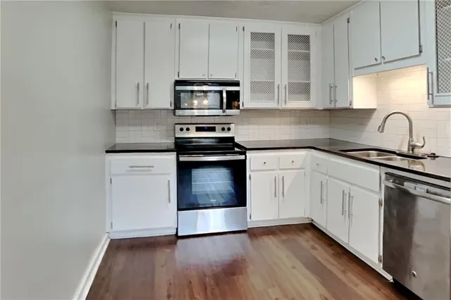 a kitchen with white cabinets stainless steel appliances and sink