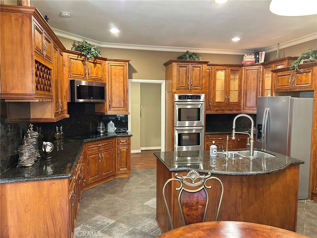 300 South Timken Road Anaheim, CA 92808 - Photo 13 of 40 a kitchen with stainless steel appliances granite countertop a refrigerator a stove top oven and a sink with wooden floor