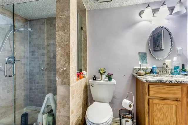 a bathroom with a granite countertop toilet sink and mirror