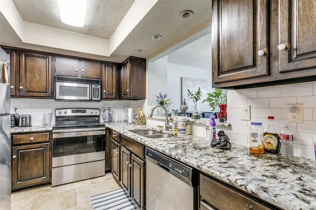 a kitchen with sink a microwave and cabinets