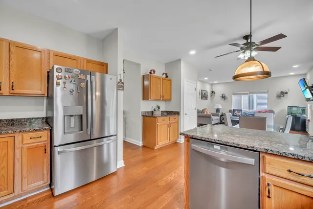 a kitchen with stainless steel appliances granite countertop a refrigerator a sink and a stove