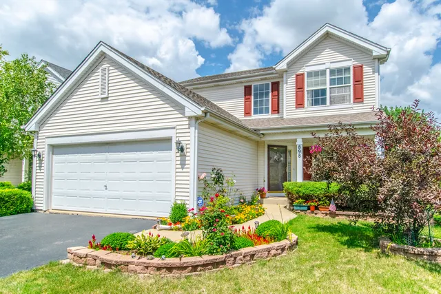 a front view of a house with a yard and potted plants