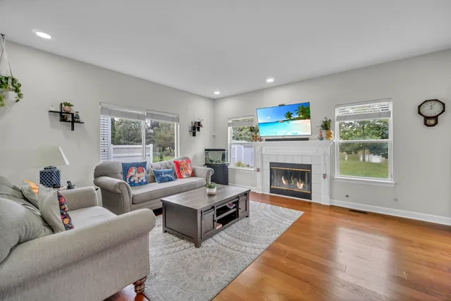 a living room with furniture a fireplace and a large window