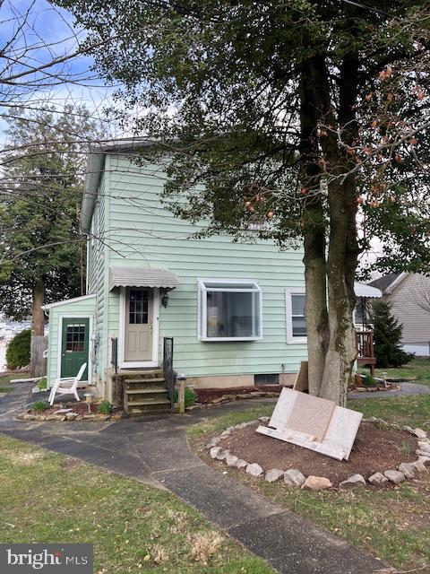 Charming green home with inviting porch.